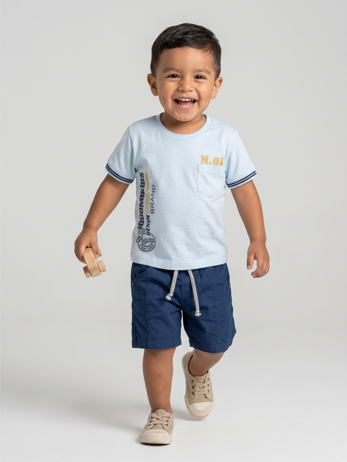 Niño con camiseta azul claro y bermuda azul oscuro